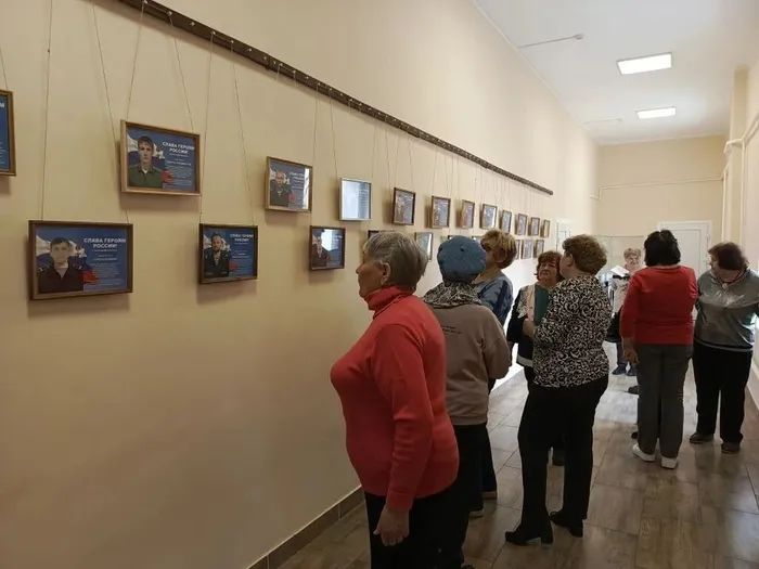 на фотографии посетители ДК знакомятся с выставкой