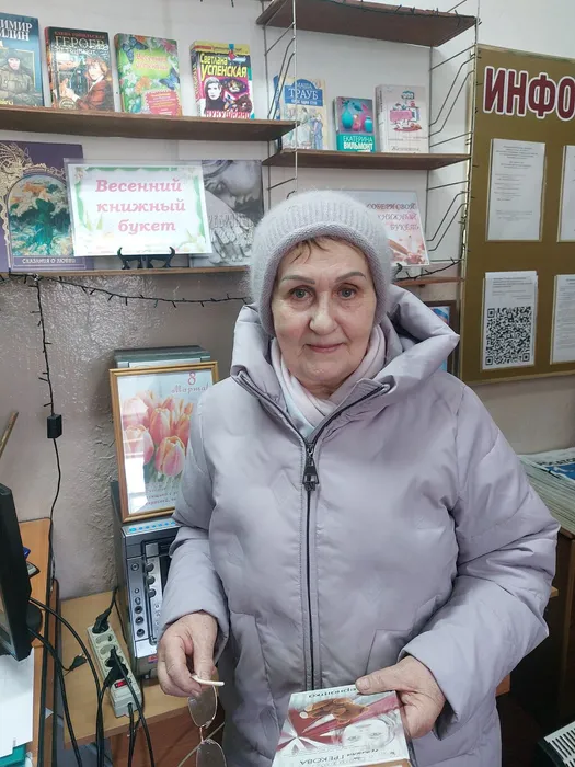 На фотографии Кулешова Г.В. с книгой выставки Весенний книжный букет