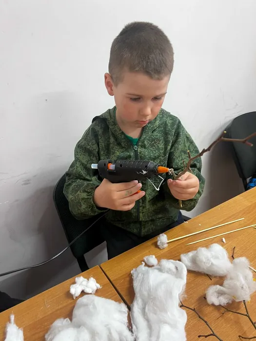 на фотографии юный посетитель Дома культуры за работой