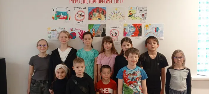 На снимке дети около выставки рисунков на тему Миру - да, террору - нет