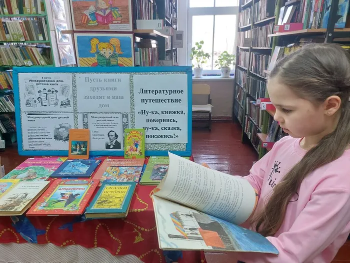 На фотографии читатель викторины ищет ответ по материалам книжной  выставки Пусть книги друзьями заходят в ваш дом