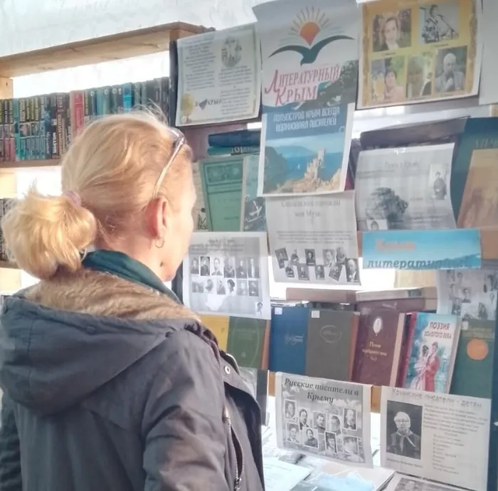 на фото посетитель библиотеки у книжной выставки