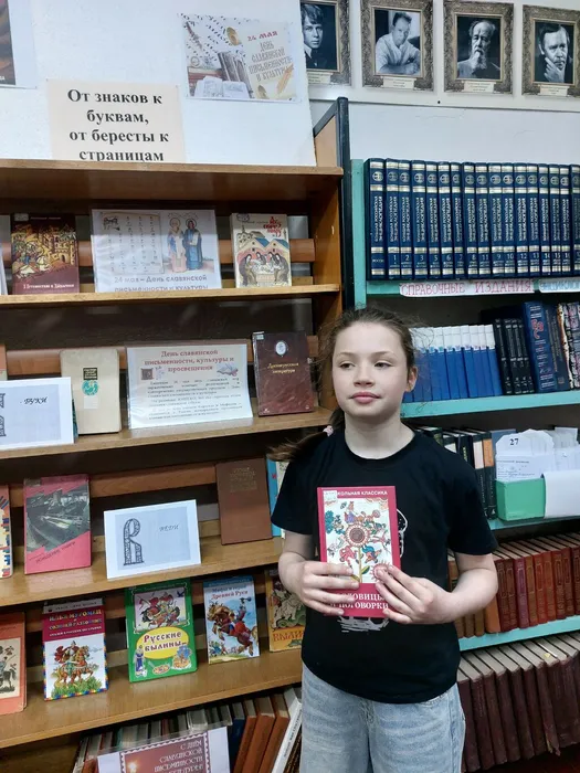На фотографии читатель у выставки с книгой пословицы и поговорки