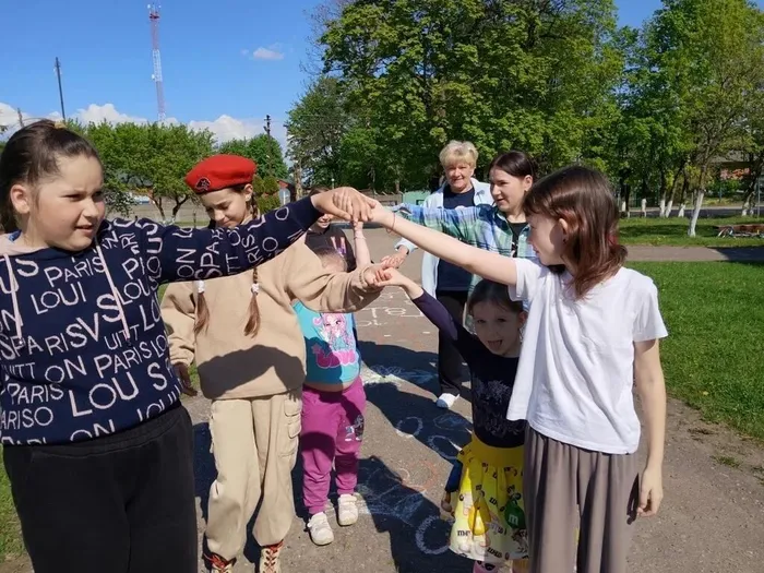 На фото участники играют в ручеёк