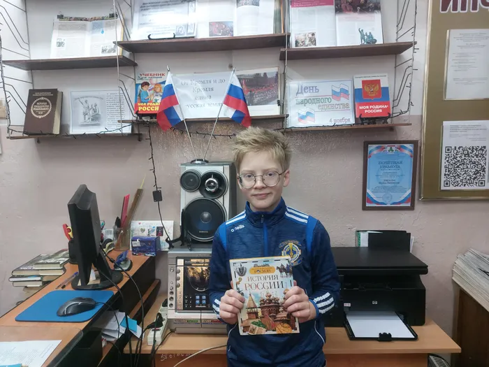 На фотографии читатель знакомится с книжной выставкой, посвященной Дню народного единства
