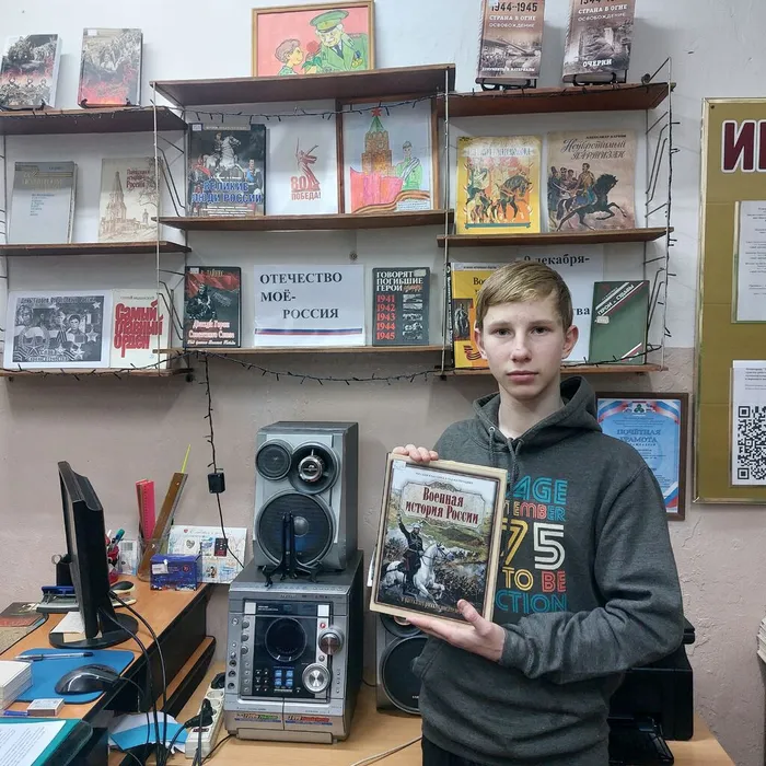 На фотографии читатель знакомится с книгой  выставки Отечество моё- Россия