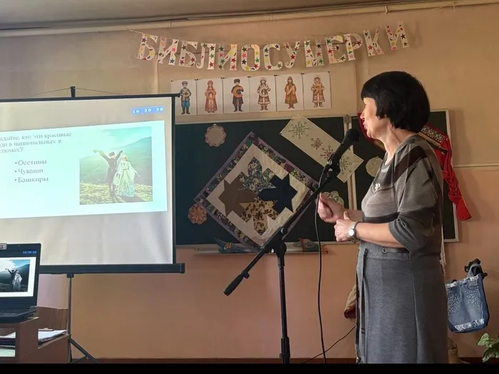 На фотографии библиотекарь проводит викторину-разминку Многоликая страна