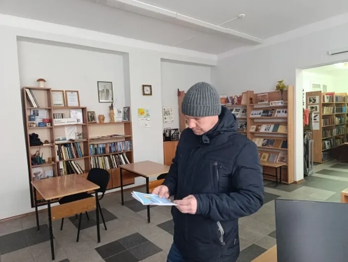 читатель Городской библиотеки за изучением информации в буклете Антитеррор