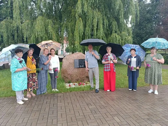 на фотографии жители города у памятного знака