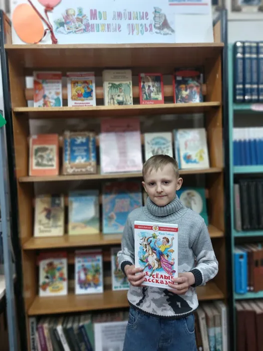 На фотографии юный читатель с книгой Юрия Сотника Весёлые рассказы