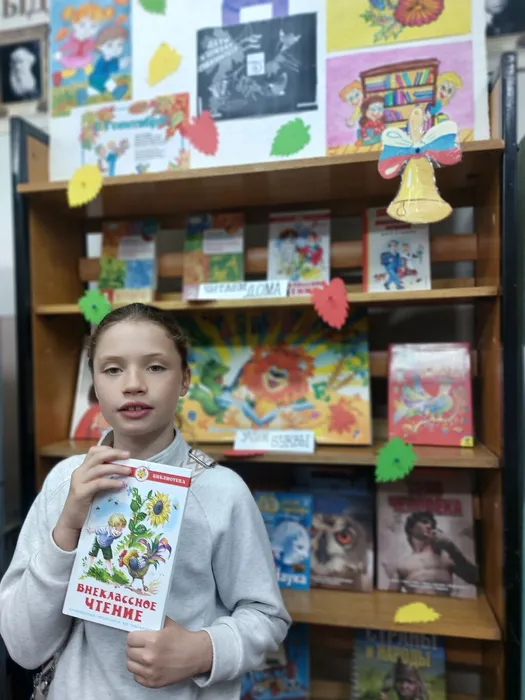 На фотографии Перепеленко Дарина с книгой хрестоматия для внеклассного чтения 4 класс