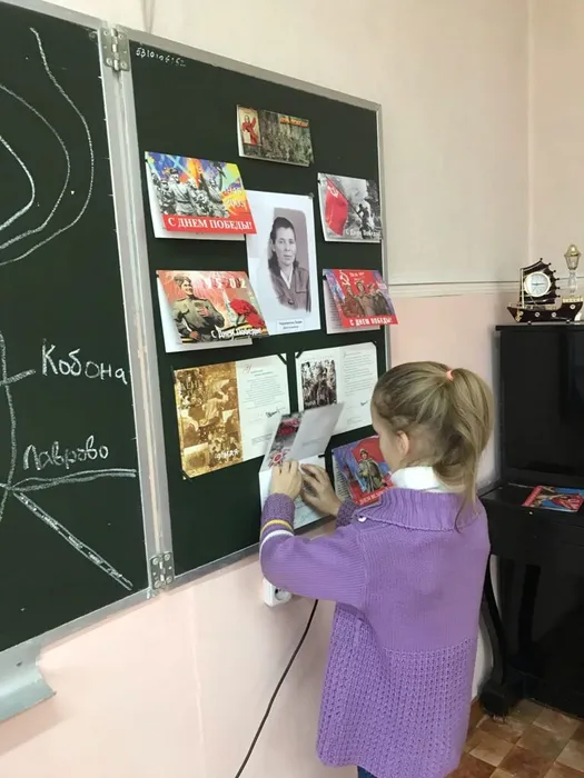 Яна Глазаускас помогает оформлять выставку открыток.jpg