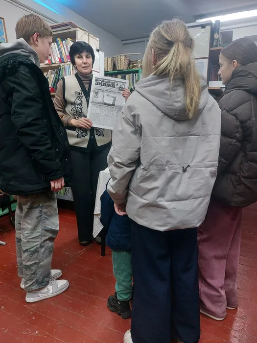 На фотографии библиотекарь ведёт информационный обзор у выставки