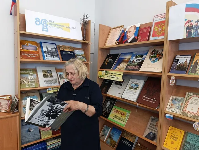 Литвинова Л. рассматривает книгу Фотографии из семейного альбома